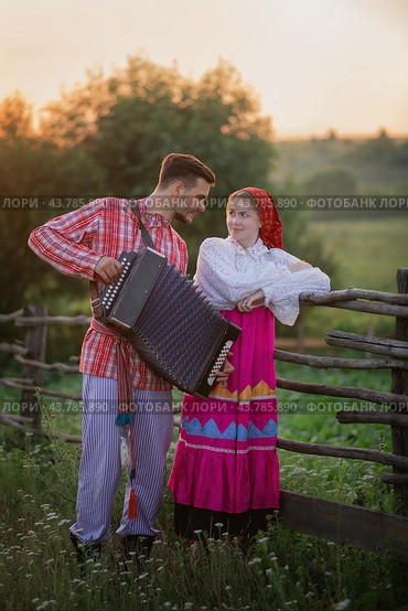 Photo of a young couple in Russian folk costumes and accordion. Стоковое фото, фотограф Elena Kosinova / Фотобанк Лори