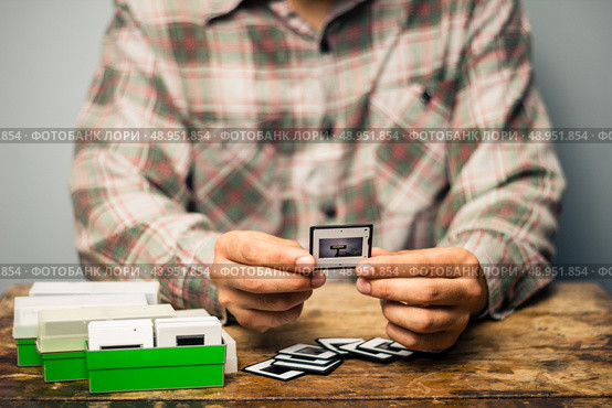 Photographer looking at his slide photos. Стоковое фото, агентство Ingram Publishing / Фотобанк Лори