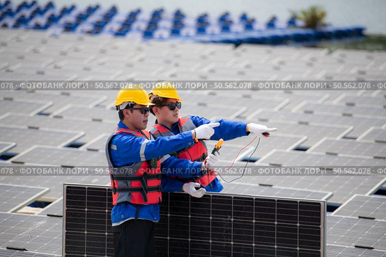 Photovoltaic engineers work on floating photovoltaics. Inspect and repair the solar panel equipment floating on the water. Стоковое фото, агентство Ingram Publishing / Фотобанк Лори
