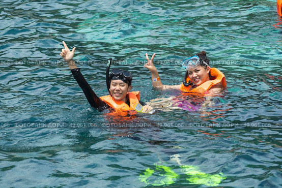 Phuket, THAILAND - JANUARY 4, 2017. A tourist wearing a bikini swim in the sea in Phuket. Редакционное фото, агентство Ingram Publishing / Фотобанк Лори