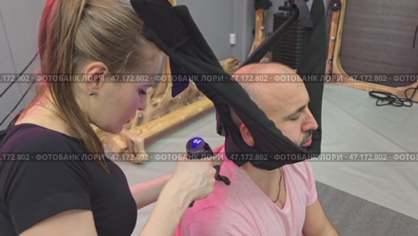 Physiotherapist using vibrating massage gun on patient's back. Стоковое видео, видеограф Юрий Поздников / Фотобанк Лори