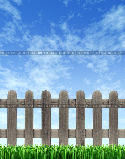 Picket wood fence on a blue sky with green grass in the foreground with weathered old grunge texture as a residential design element. Стоковое фото, агентство Ingram Publishing / Фотобанк Лори