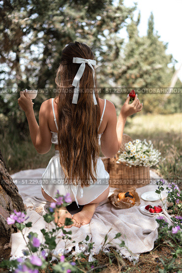 Picnic Woman Strawberries: Sunny day, woman enjoys picnic with strawberries and coffee in a serene meadow. Стоковое фото, фотограф svetograph / Фотобанк Лори