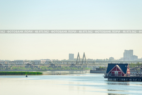 Picturesque view of the river Kazanka, a coastal house and a cable-stayed bridge Millennium Bridge. Russia (2022 год). Стоковое фото, фотограф Константин Лабунский / Фотобанк Лори