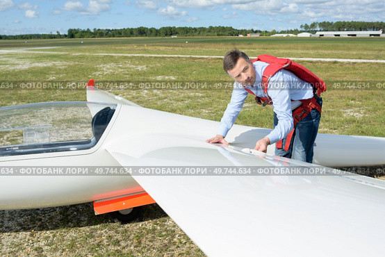 Pilot looking at wing of sailplane. Стоковое фото, агентство Ingram Publishing / Фотобанк Лори