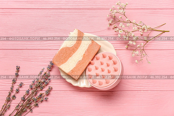 Plate with hair scalp massager, shampoo bar and flowers on pink wooden background. Стоковое фото, фотограф Pixel_shot / Фотобанк Лори