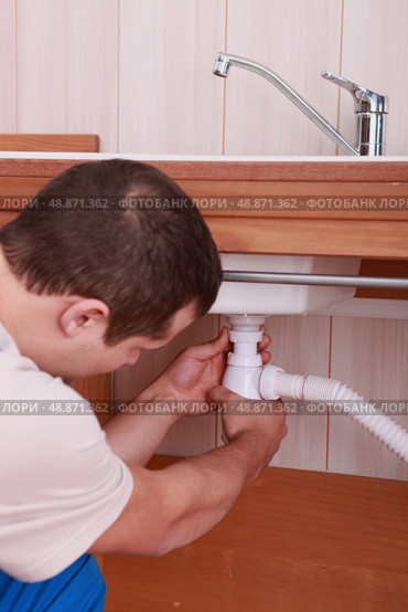 Plumber screwing siphon. Стоковое фото, агентство Ingram Publishing / Фотобанк Лори