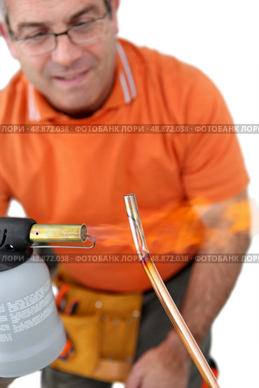 Plumber soldering pipe. Стоковое фото, агентство Ingram Publishing / Фотобанк Лори