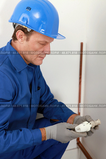Plumber with a radiator valve. Стоковое фото, агентство Ingram Publishing / Фотобанк Лори