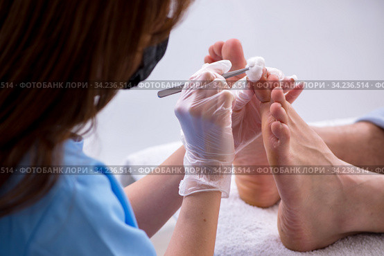 Podiatrist treating feet during procedure. Стоковое фото, фотограф Elnur / Фотобанк Лори