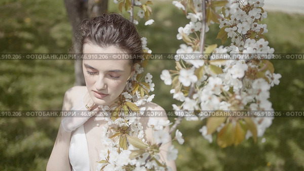 Poetic image of beautiful woman with blooming apple tree. Стоковое фото, фотограф David Kashakhi / Фотобанк Лори