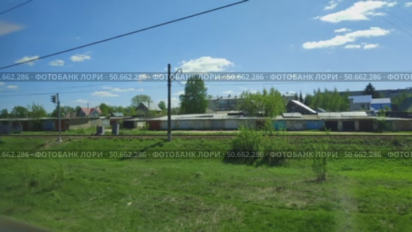 Поезд проезжает мимо маленького поселка. Вид из окна вагона. Железнодорожное сообщение между городами. Прекрасный летний пейзаж с голубым небом и яркой зеленью. Train passes by small village. View from carriage window. Railway connection between cities. Beautiful summer landscape with blue sky and bright greenery. Стоковое видео, видеограф Ирина / Фотобанк Лори