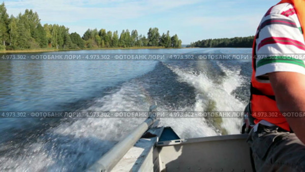 Поездка на моторной лодке, вид на корму с сидящим у мотора человеком. Стоковое видео, видеограф Кекяляйнен Андрей / Фотобанк Лори