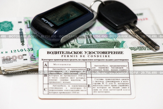 Покупка машины. Водительские права, стопка денег и ключ от автомобиля с брелоком от сигнализации на светлом фоне (2019 год). Редакционное фото, фотограф Игорь Низов / Фотобанк Лори