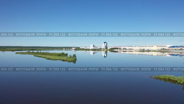 Полет над озером и зеркальное отражение офиса ОАО "Газпром добыча Надым" в полный штиль, Ямало-Ненецкий автономный округ (2019 год). Стоковое видео, видеограф Григорий Писоцкий / Фотобанк Лори