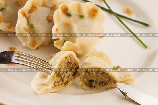 polish pierogi dish - dumplings with meat close up, one dumpling in sliced. Стоковое фото, агентство Ingram Publishing / Фотобанк Лори