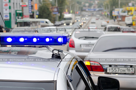 Полицейский автомобиль со спецсигналами в потоке автомобилей на городской улице, фрагмент. Ростов-на-Дону (2012 год). Редакционное фото, фотограф Олег Пчелов / Фотобанк Лори