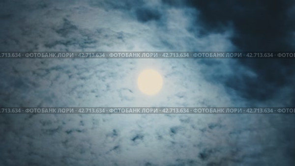Полная луна с облаками, разгоняемыми ветром, в середине осени. Яркая луна движется по небу, покрытому пористыми белыми облаками. Таймлапс полной луны. Стоковое видео, видеограф Воловодов Владимир / Фотобанк Лори