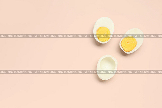 Половинки вкусных отваренных яиц на розовом фоне. Стоковое фото, фотограф Pixel_shot / Фотобанк Лори