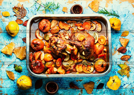 Pork knuckle stewed with quince and apples in tray. Pork shank baked with apples. Стоковое фото, агентство Ingram Publishing / Фотобанк Лори