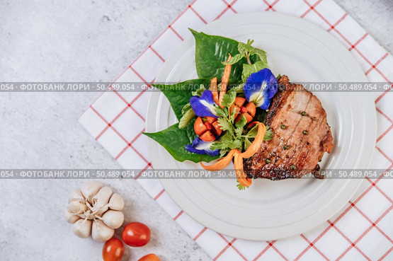 Pork Steak with Tomato, Carrot, Red Onion, Peppermint, Butterfly Pea Flower, and Lime. Стоковое фото, агентство Ingram Publishing / Фотобанк Лори