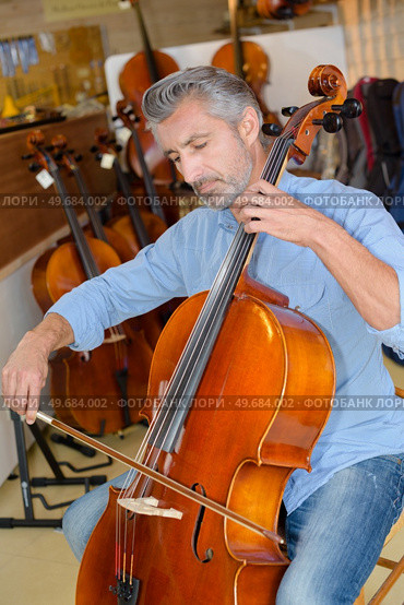 portait of cellist testing the cello. Стоковое фото, агентство Ingram Publishing / Фотобанк Лори