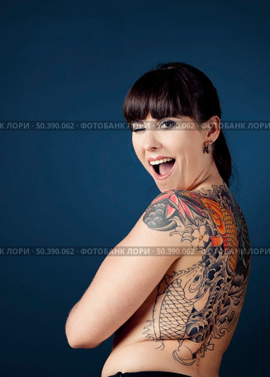 Portrait of a beautiful young woman with tattoos and winking. Стоковое фото, агентство Ingram Publishing / Фотобанк Лори