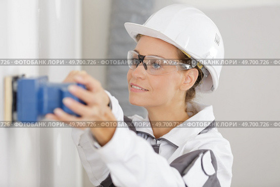 portrait of a builder woman sanding wall. Стоковое фото, агентство Ingram Publishing / Фотобанк Лори