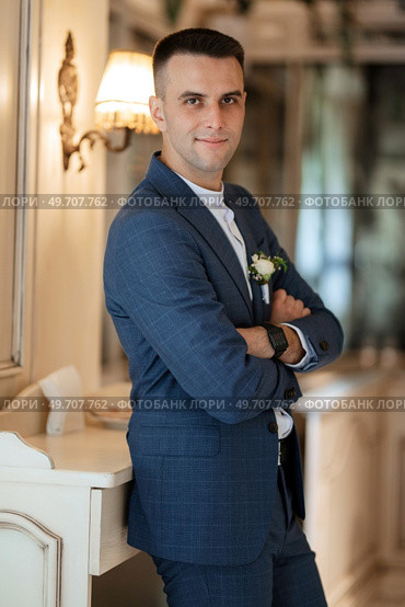 portrait of a groom in a gray plaid suit with a tie in a light bar with mirrors. Стоковое фото, агентство Ingram Publishing / Фотобанк Лори
