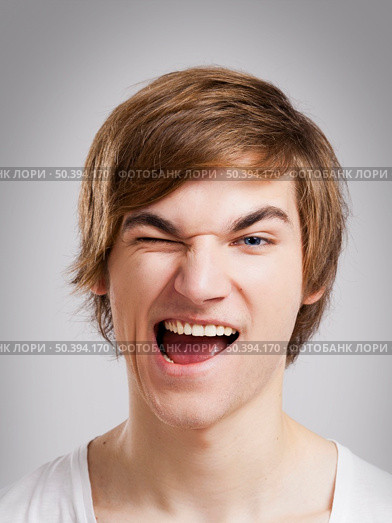 Portrait of a handsome young man, over a gray background. Стоковое фото, агентство Ingram Publishing / Фотобанк Лори