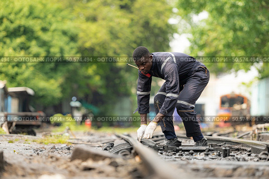 Portrait of a railway engineer on the tracks of a train in station platform. Стоковое фото, агентство Ingram Publishing / Фотобанк Лори