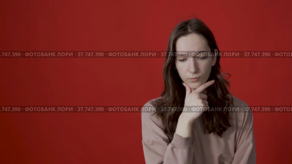 Portrait of a thoughtful young woman with long hair, thinking intensely, pondering a solution to a problem. Стоковое видео, видеограф Владимир Федоров / Фотобанк Лори