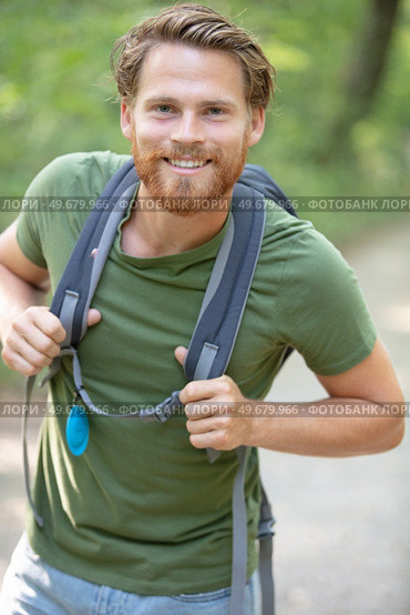 portrait of a young smiling wanderer man with backpack. Стоковое фото, агентство Ingram Publishing / Фотобанк Лори
