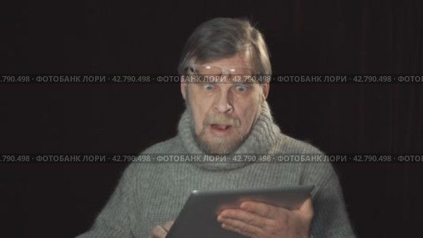 Portrait of an adult man with a tablet. Emotions shocked, surprise. Стоковое видео, видеограф EStarodubov / Фотобанк Лори