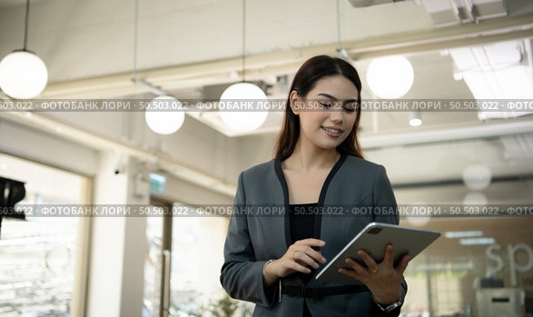 Portrait of Business female rookie in the new entrepreneurial with a tablet as a tool to help in the work. Стоковое фото, агентство Ingram Publishing / Фотобанк Лори