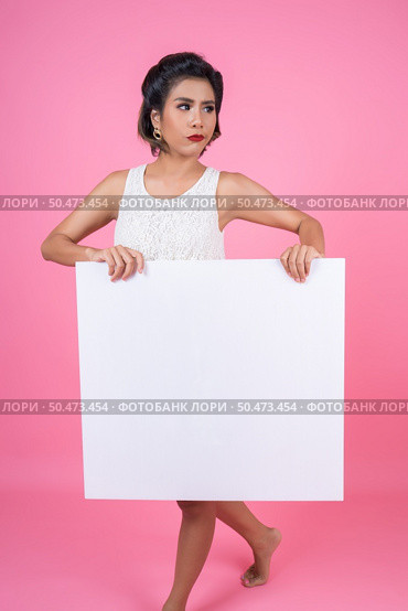 Portrait of fashion woman displaying white banner. Стоковое фото, агентство Ingram Publishing / Фотобанк Лори