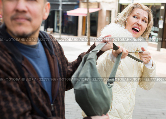 Portrait of frightened mature woman and robber. Стоковое фото, фотограф Яков Филимонов / Фотобанк Лори