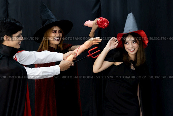Portrait of group of friends asian young adult people wear Halloween costume to be witches and dracula character. Halloween celebrate and international holiday concept. Стоковое фото, агентство Ingram Publishing / Фотобанк Лори