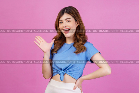 Portrait of happy young woman wearing casual t-shirt waving hands isolated over pink background. Expression, people and lifestyle concept. Стоковое фото, агентство Ingram Publishing / Фотобанк Лори