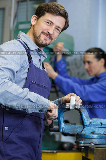 portrait of male engineer using vice. Стоковое фото, агентство Ingram Publishing / Фотобанк Лори
