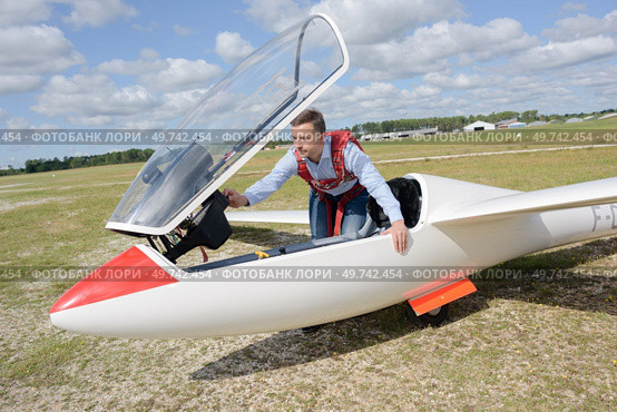 portrait of man getting into glider. Стоковое фото, агентство Ingram Publishing / Фотобанк Лори