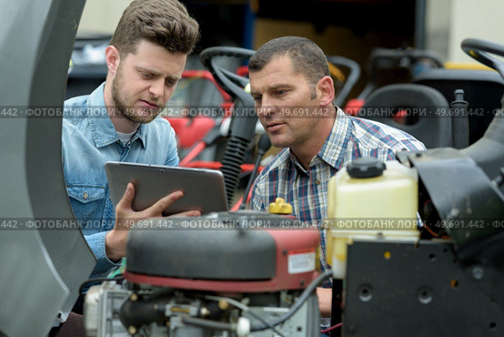 portrait of men fixing a lawn mower. Стоковое фото, агентство Ingram Publishing / Фотобанк Лори