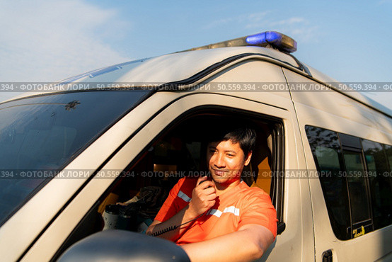 Portrait of paramedic team in ambulance use walkie talkie is assist an injured in an emergency situation on the road. Стоковое фото, агентство Ingram Publishing / Фотобанк Лори