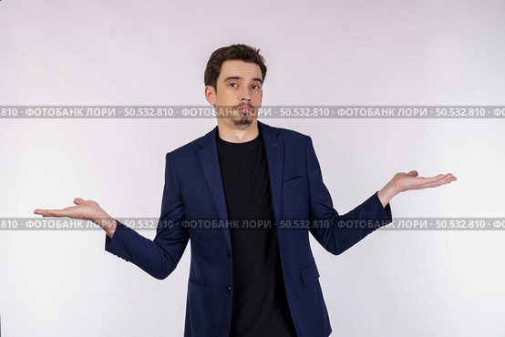 Portrait of puzzled clueless young businessman arms out asking why what’s the problem who cares so what, I don’t know on isolated background. Стоковое фото, агентство Ingram Publishing / Фотобанк Лори