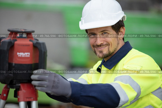 portrait of surveyor next to theodolite machine. Стоковое фото, агентство Ingram Publishing / Фотобанк Лори