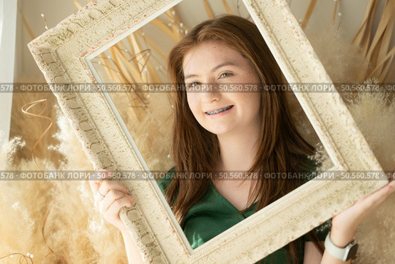 Portrait of Teenage girl with braces in picture frame. Стоковое фото, агентство Ingram Publishing / Фотобанк Лори
