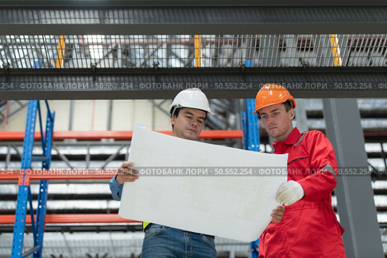 Portrait of two engineer discussing blueprints of electric train machinery Before undergoing regular inspection after being used for transporting passengers for a period of time. Стоковое фото, агентство Ingram Publishing / Фотобанк Лори