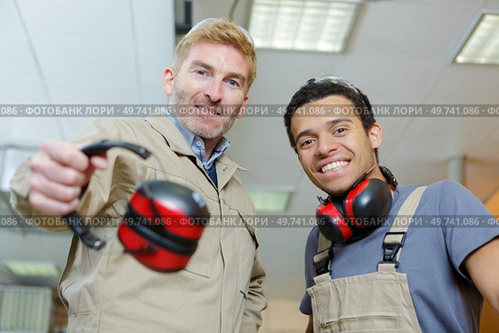 portrait of two workmen with earmuffs. Стоковое фото, агентство Ingram Publishing / Фотобанк Лори
