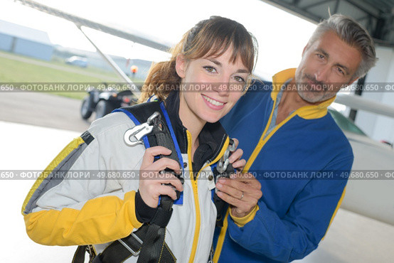 Portrait of woman being prepared for parachute jump. Стоковое фото, агентство Ingram Publishing / Фотобанк Лори