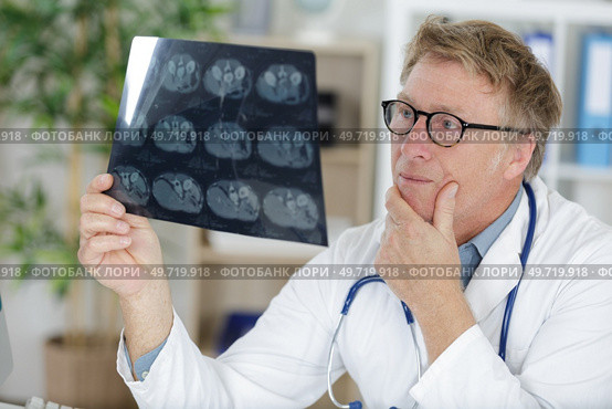 portrait senior doctor over radiography. Стоковое фото, агентство Ingram Publishing / Фотобанк Лори